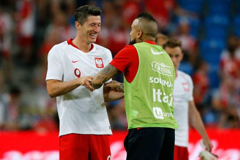 Arturo Vidal se saluda con el polaco Robert Lewandowski.