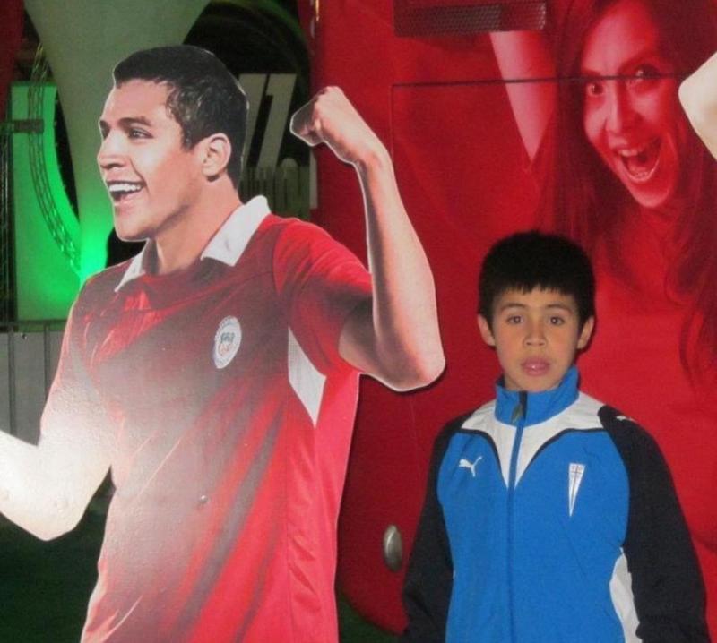 Un pequeño Alexander Aravena junto a la imagen de Alexis Sánchez. (Archivo)