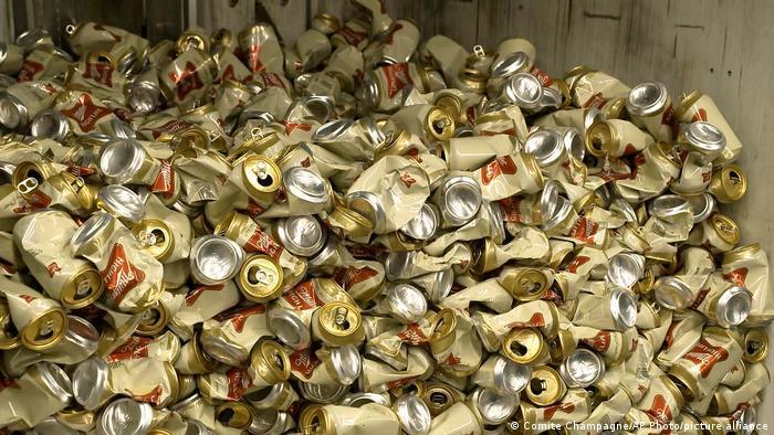 Deutsche Welle - Latas de cerveza Miller High Life reposan en un contenedor tras ser aplastadas.