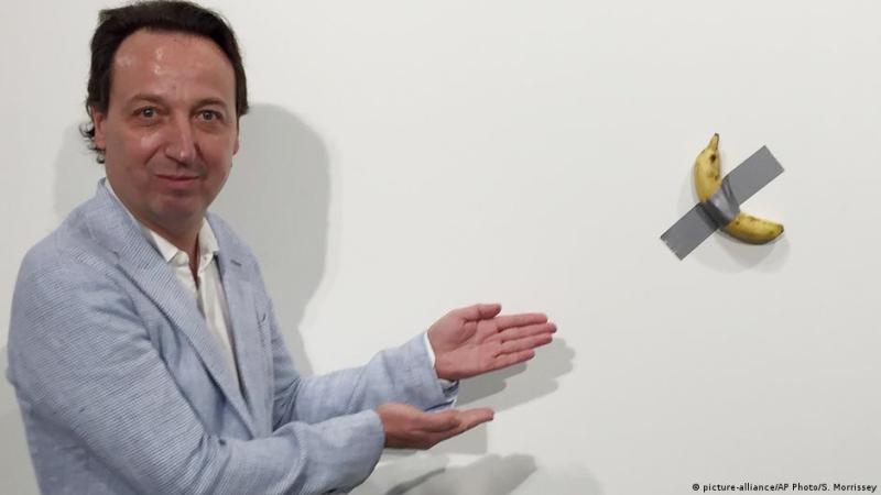 El artista italiano Maurizio Cattelan junto a su obra.