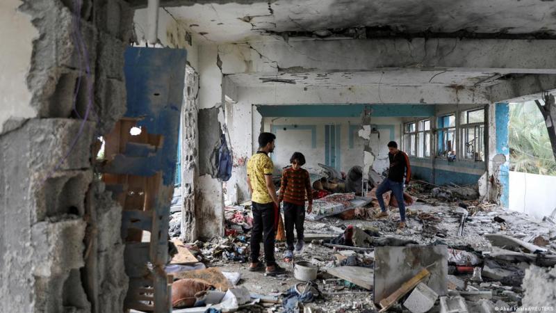 Deutsche Welle - Palestinos inspeccionan los restos de una escuela de la UNRWA, en el campo de refugiados de Nuseirat en el centro de la Franja de Gaza, que fue blanco de un ataque israelí el 6 de junio de 2024.