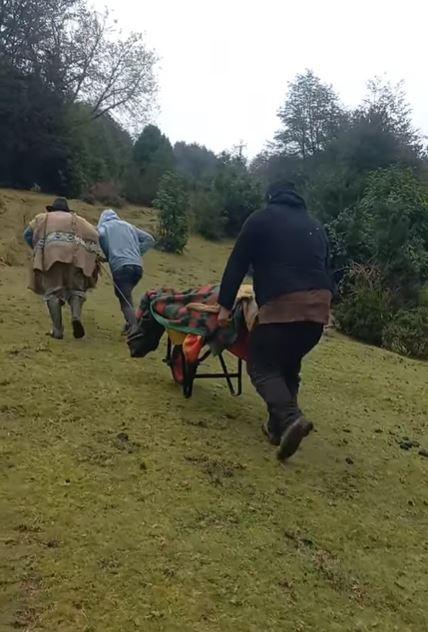 Vecinos llevan a un paciente en carretilla