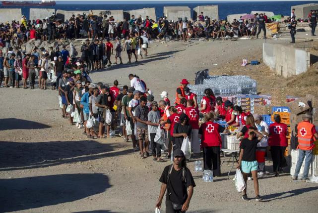 Archivo: voluntarios de la Cruz Roja distribuyen alimentos a los migrantes que permanecen en Ceuta, en una playa del enclave español en Marruecos, el 22 de agosto de 2026. © Antonio Sempere/AFP