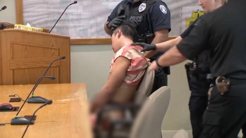 Cargado por cuatro policías y con los tobillos engrillados: así compareció acusado de asesinar a tiros a su padre y madrastra - Captura de video: WKYC