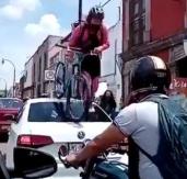 Ciclista pasa por arriba de un auto estacionado en un ciclovía en México