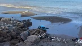 Impactante imagen en Iquique: Autos que colgaban desde cerro tras aluvión llegaron a la playa y quedaron a metros del mar