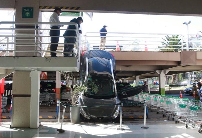Auto cae desde estacionamiento en Las Condes