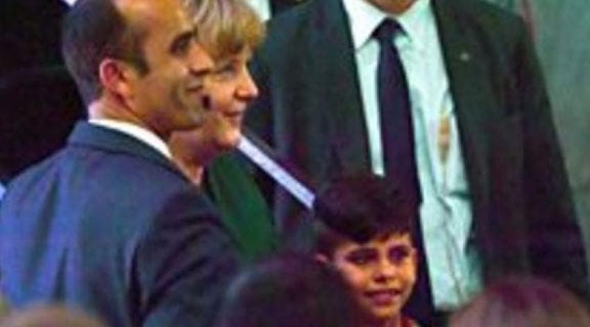 Niño afgano le quiere agarrar la mano a Angela Merkel para "agradecerle" por su vida en Alemania