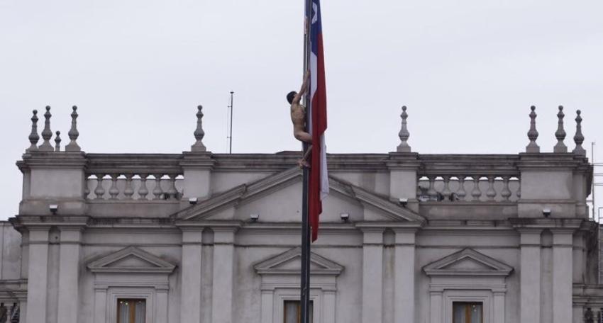 Un hombre desnudo trepa un mástil frente al Palacio de La Moneda