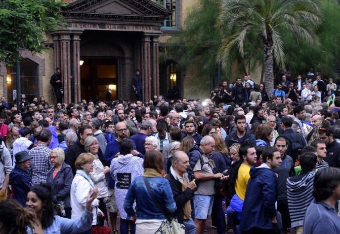 Cientos de personas esperan afuera de los recintos de votación en Cataluña