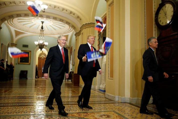 Manifestante arroja banderas rusas a Trump en el Capitolio
