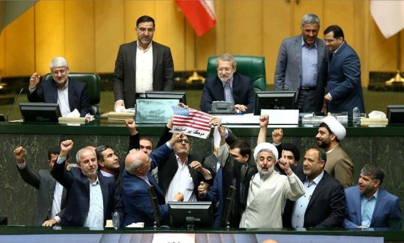 Queman una bandera estadounidense de papel en el parlamento iraní