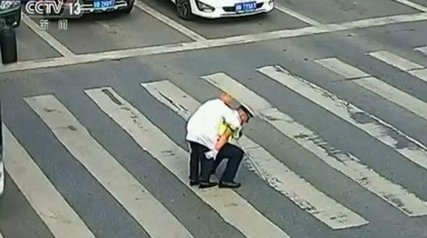 [VIDEO] Llevándolo en su espalda, un policía ayudó a un adulto mayor a cruzar la calle en China
