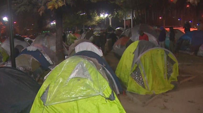 [VIDEO] Esperan fuera de las embajadas: Migrantes se preparan para enfrentar la lluvia y el frío