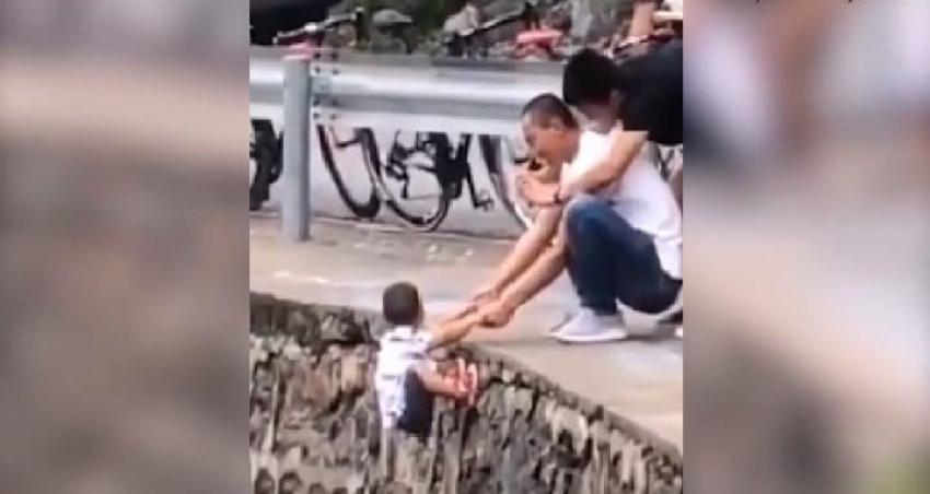 Todo por una foto: padre es captado colgando a su hijo de un abismo en China