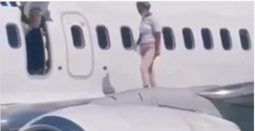 Pasajera de avión abre puerta de emergencia porque tenía "calor" y camina sobre el ala de la máquina