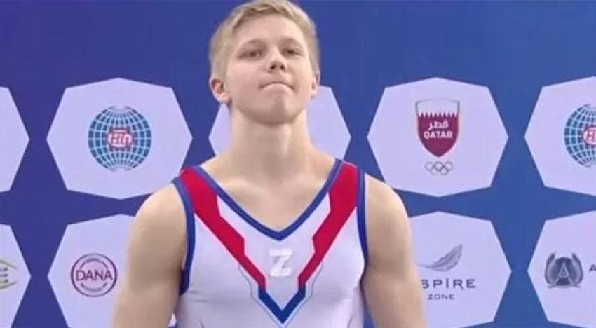 Gimnasta ruso sube al podio de competencia con símbolo de los tanques de milicias de Rusia