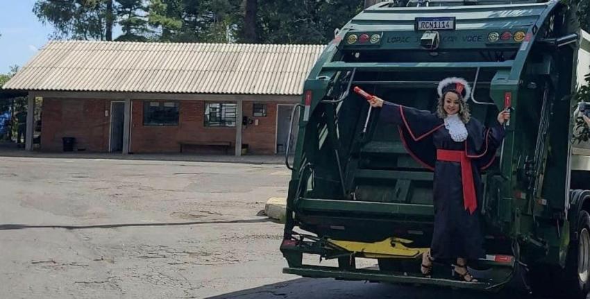 Abogada recién graduada se toma una foto junto al camión de basura en el que trabajó por 12 años