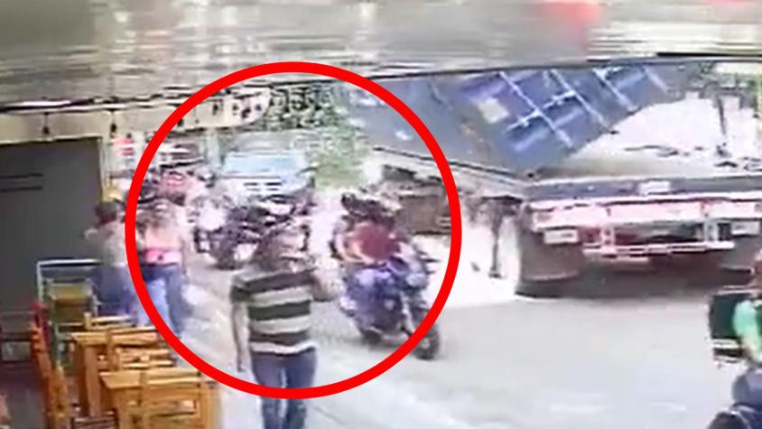 VIDEO | Un milagro: Motociclista se salvó de morir aplastado por un container