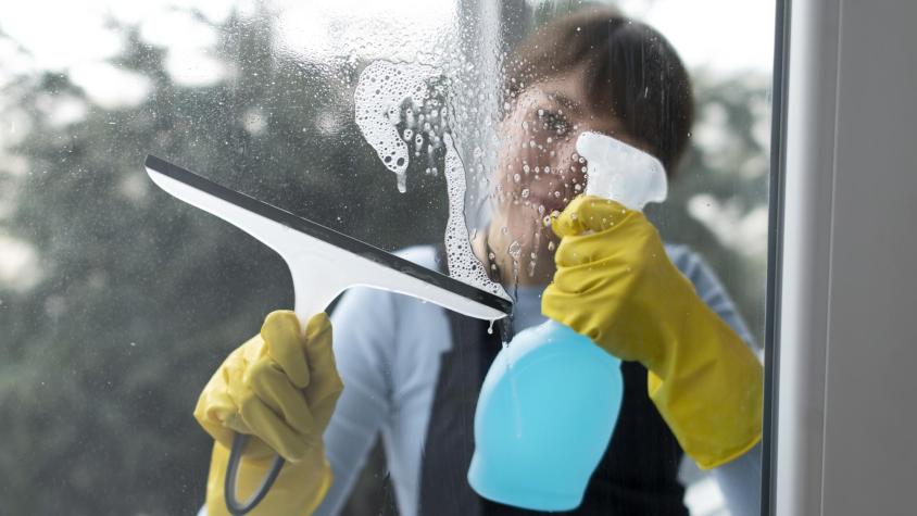 Afirmada solo de una baranda: Trabajadora es captada arriesgando la vida para limpiar vidrios de departamento en Vitacura
